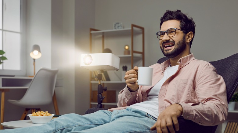 Man watching movie with projector