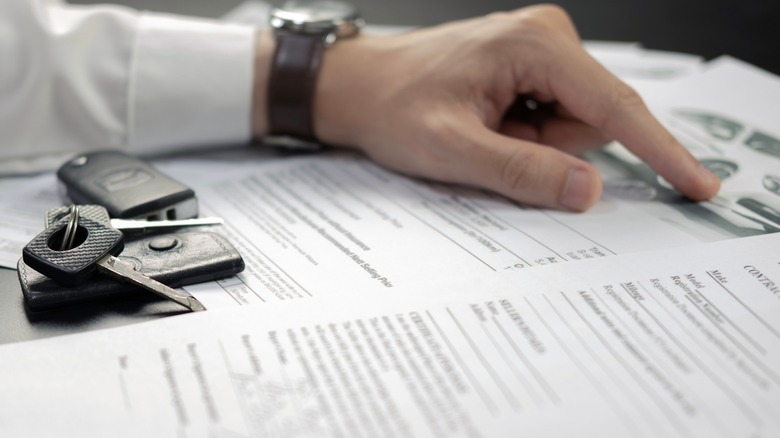 Person reviewing document with car keys