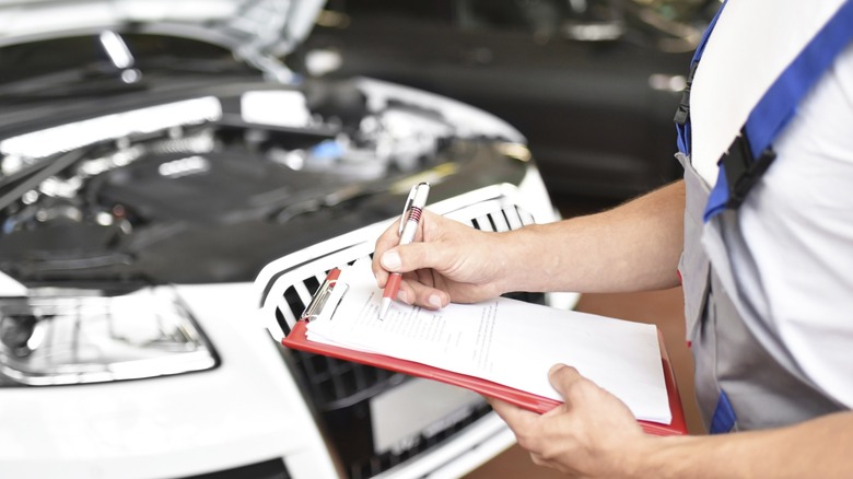 Ticking checklist in front of a vehicle