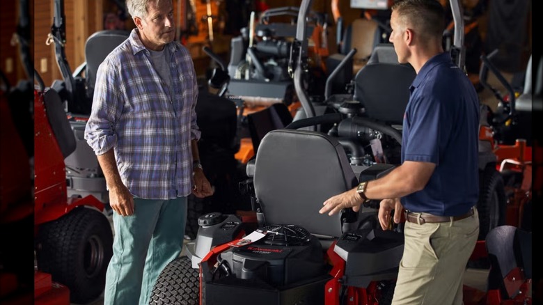 Two people discussing a Kawasaki engine.