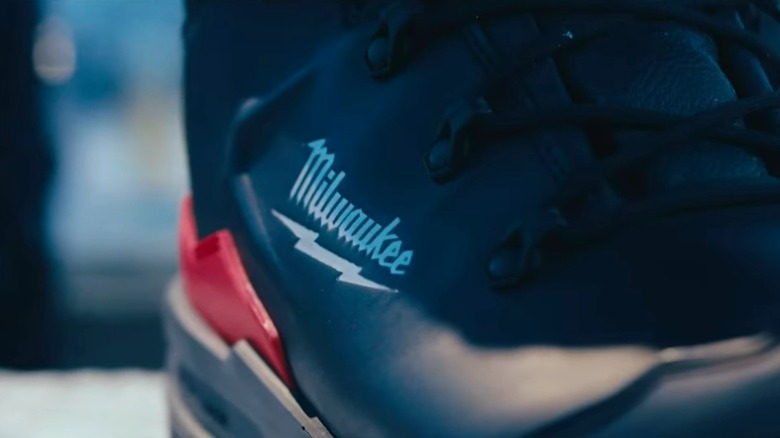 A close-up of a black, white, and red Milwaukee work boot.