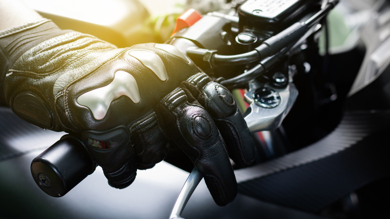 gloved hand on motorcycle throttle control