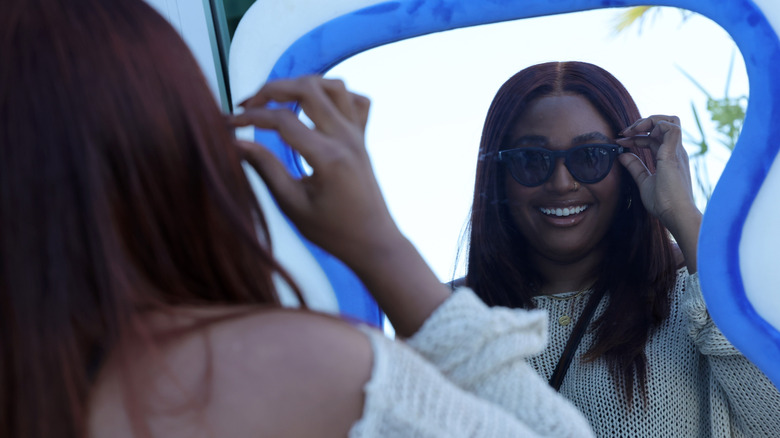 Woman wearing Ray-Ban Meta AI Glasses and looking at herself in the mirror