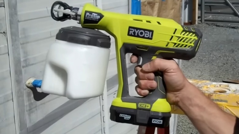 Person holding paint sprayer