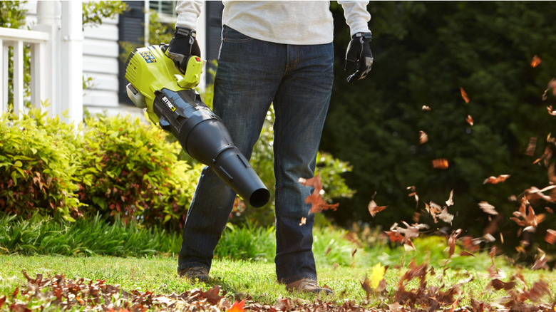 Handheld Ryobi gas blower in action