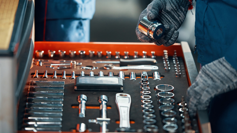 Hands of a person working with wrenches and sockets