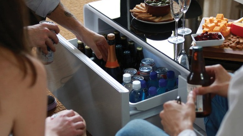 People gathered around the SOBRO coffee table, with one drawer open