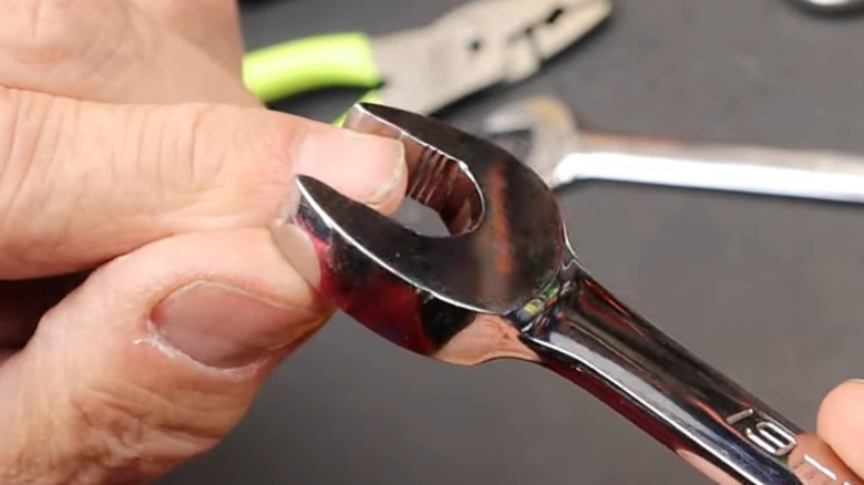 a person showcasing the grooves cut into a snap-on flank drive plus wrench