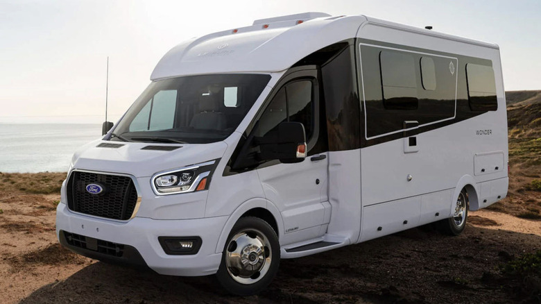 White travel van sitting on the beach