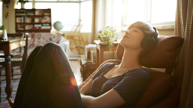 Person reclining in chair listening to headphones