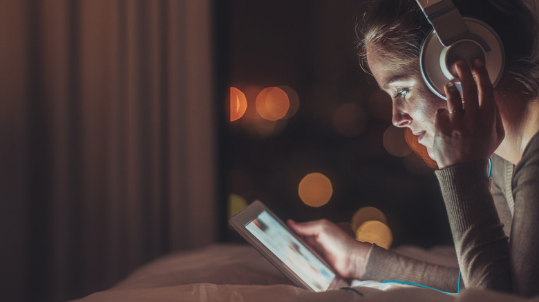 Woman wearing headphones and using tablet