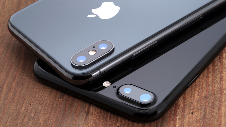 two old iPhone models stacked on table