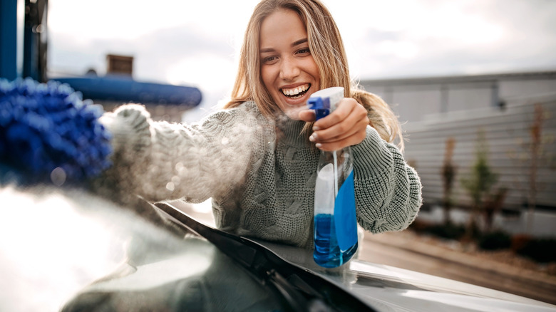 Woman cleaning her car windshield