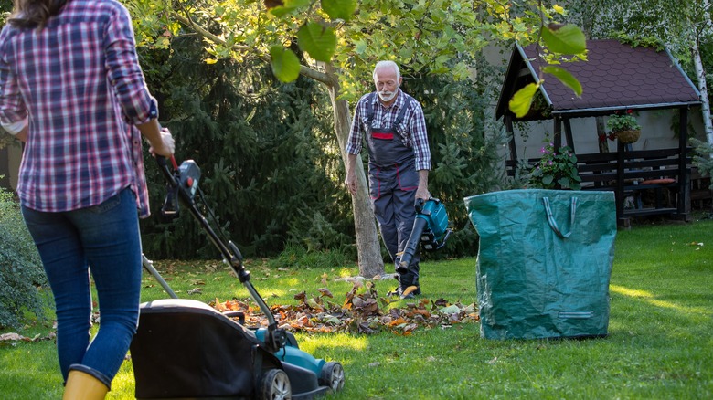 senior man using a handheld leaf blower