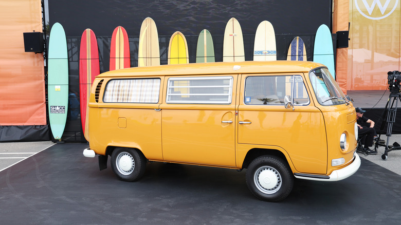 Yellow VW beetle bus with surfboards