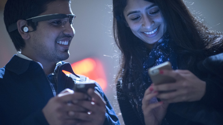 Two people phones smiling