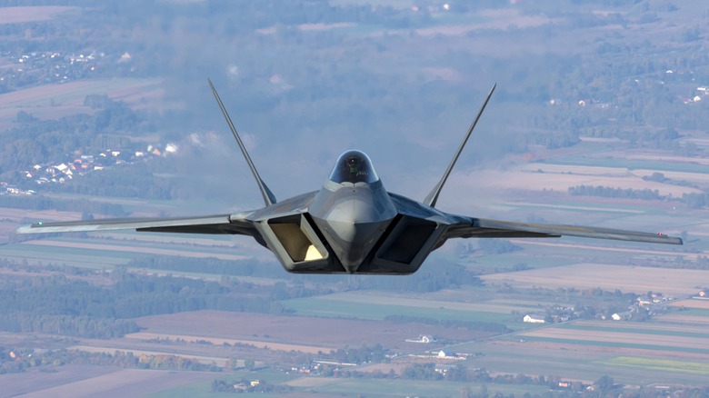 F-22 Raptor flying over farmland