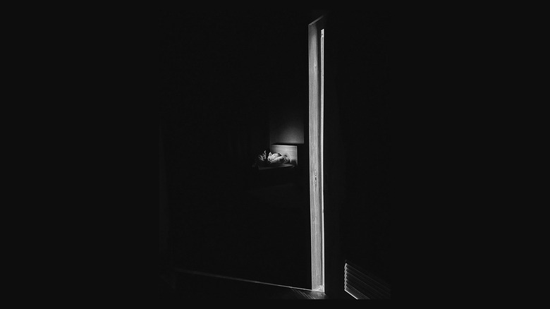 Person lying in bed in black and white