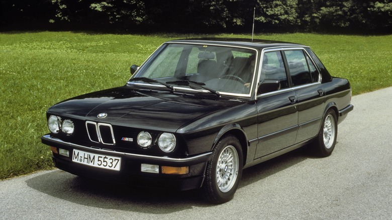 Black BMW M5 E28 driving on a road