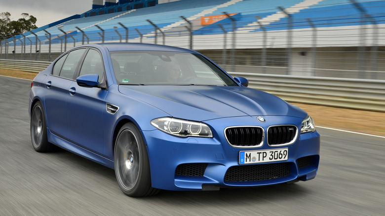 Blue BMW M5 F10 driving fast on a track