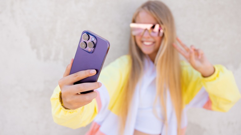 girl taking selfie with iphone