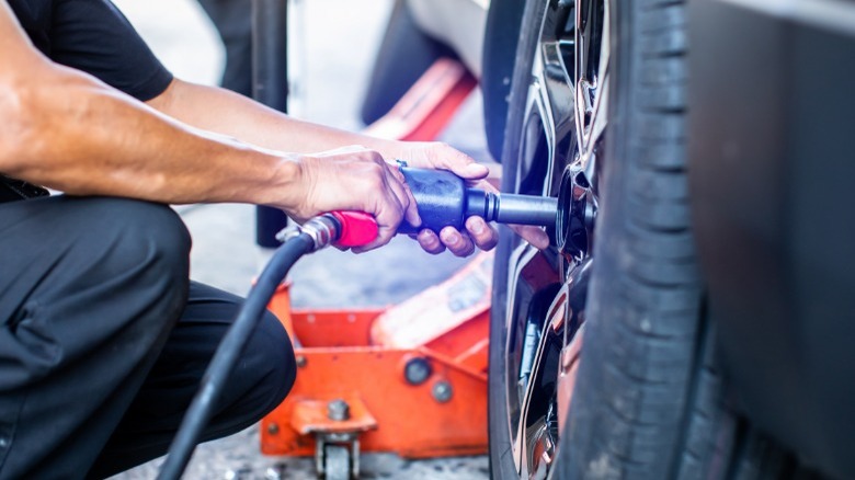 mechanic using pneumatic impact wrench