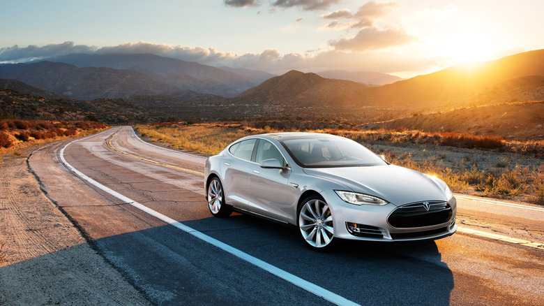 A Tesla Model 3 driving down an open road