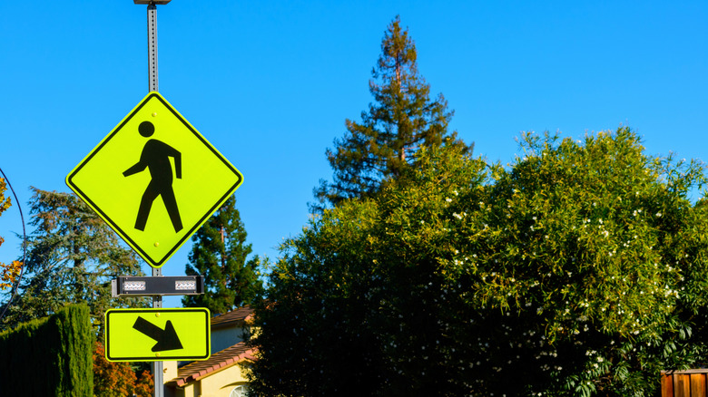 A yellow and black "pedestrian crossing" sign.