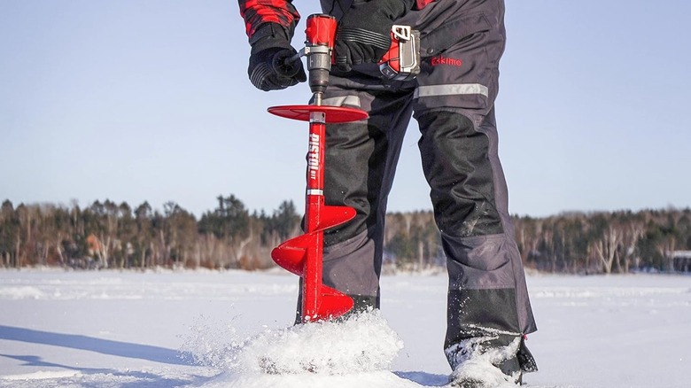 Person using cordless power drill as an ice auger