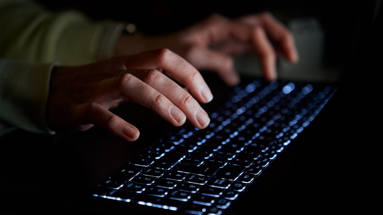 hands typing on keyboard semidarkness