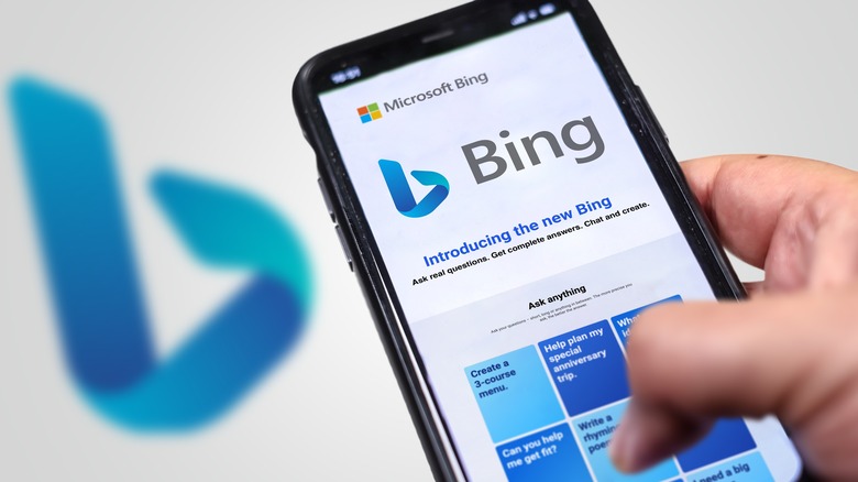 Bing app on phone in front of out of focus Bing logo