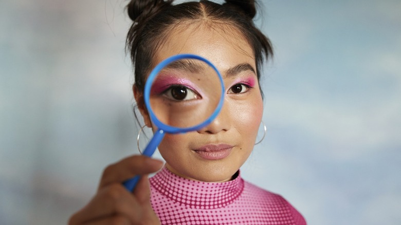 Woman looking through a magnifying glass