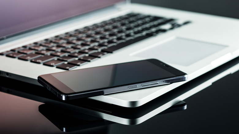 smartphone resting on an open Macbook