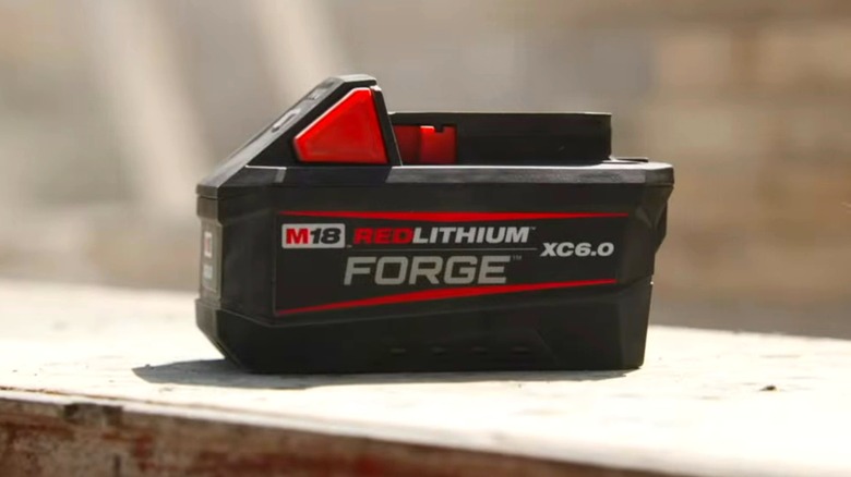 A Milwaukee battery on a wood surface