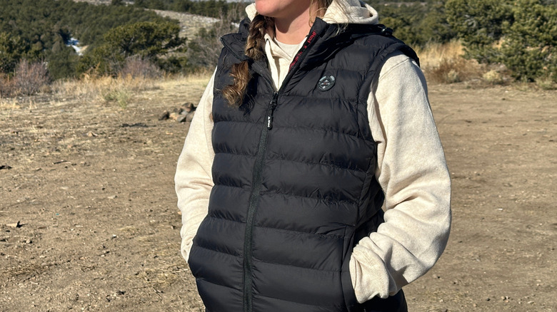 Girl standing outside wearing a black vest