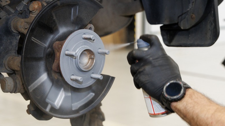 Spraying brake cleaner onto bolts