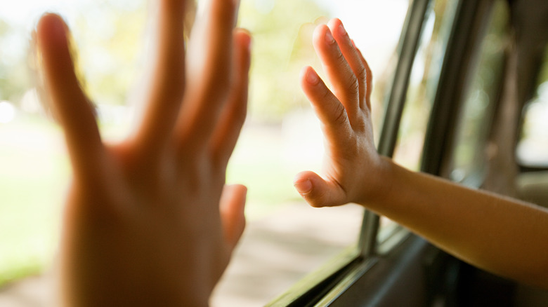 Kid's hands on car window