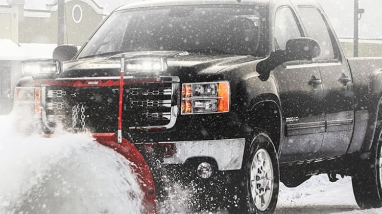 A truck plowing snow with a Western Plow.