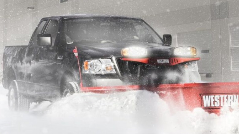 A truck plowing snow with a Western Plow.