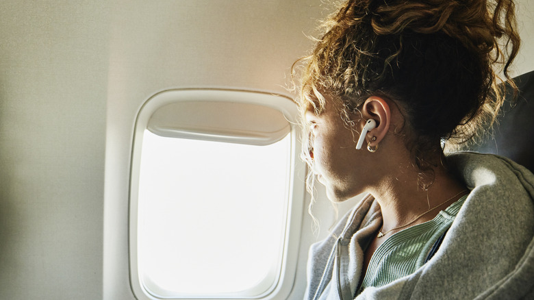 woman with headphones on plane