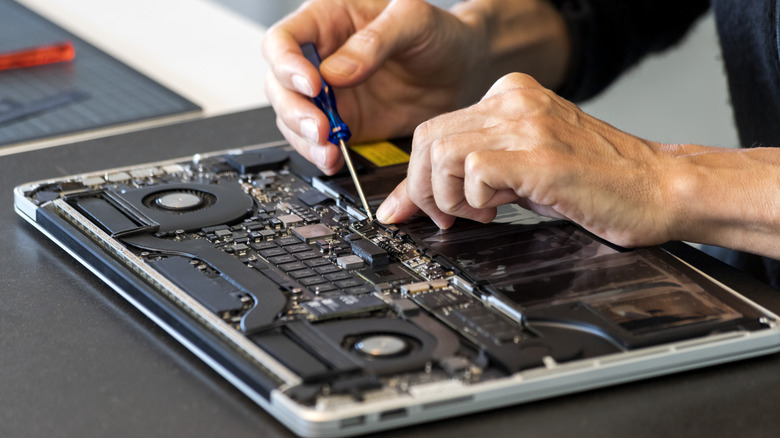 Person fixing an opened laptop