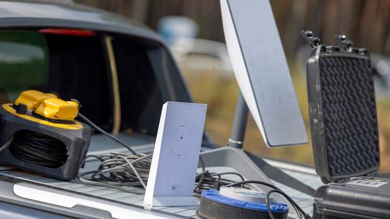 Starlink dish with router and cable on top of vehicle