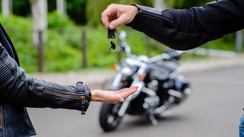 Person getting keys to motorcycle