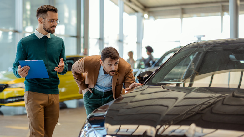 Salesman talking to male customer at the dealership