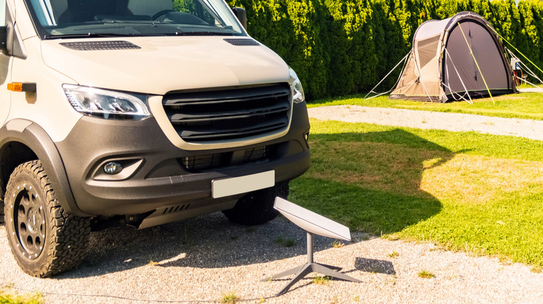 A Starlink dish sitting in front of a van