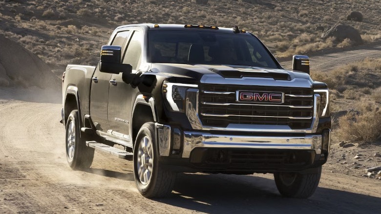 Black 2024 GMC Sierra HD on dirt road