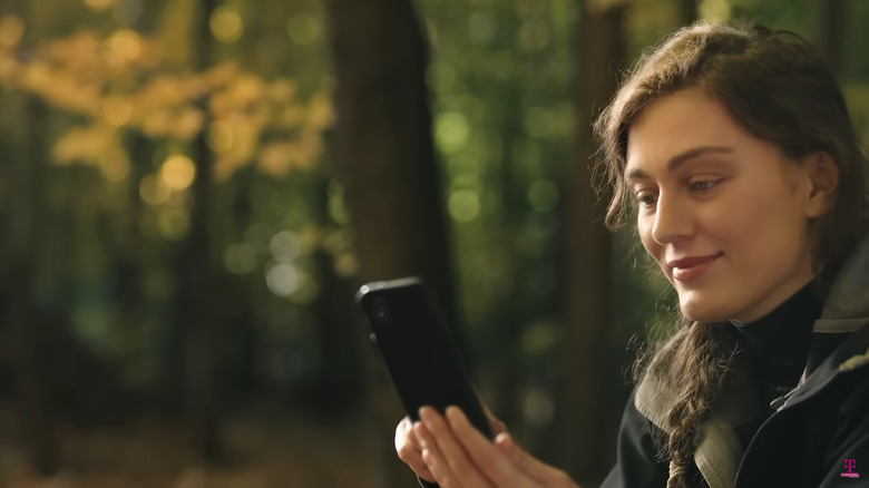 Woman holding phone while in the wilderness