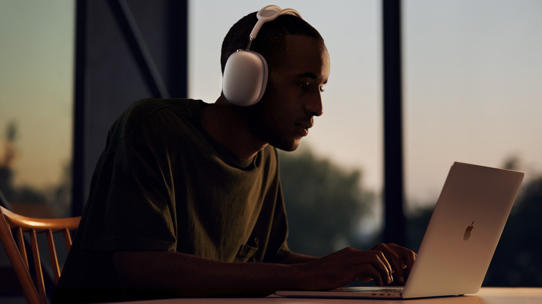 Man using AirPods Max with MacBook