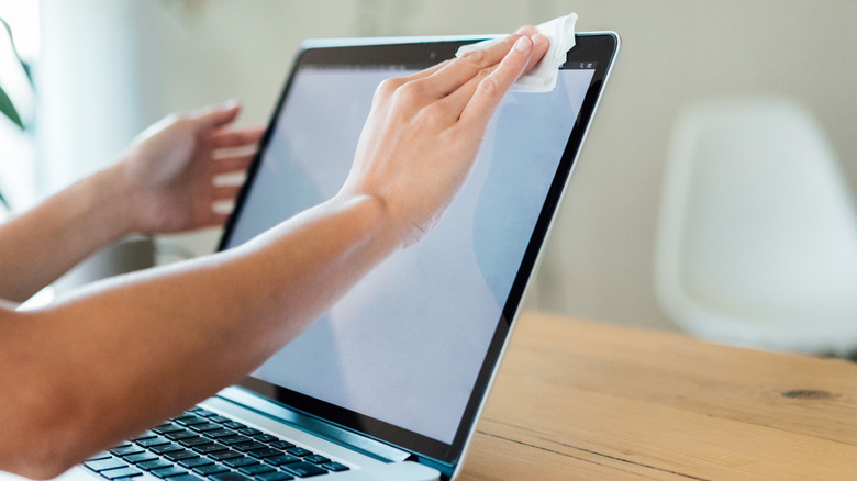 cleaning laptop screen with a cleaning wipe