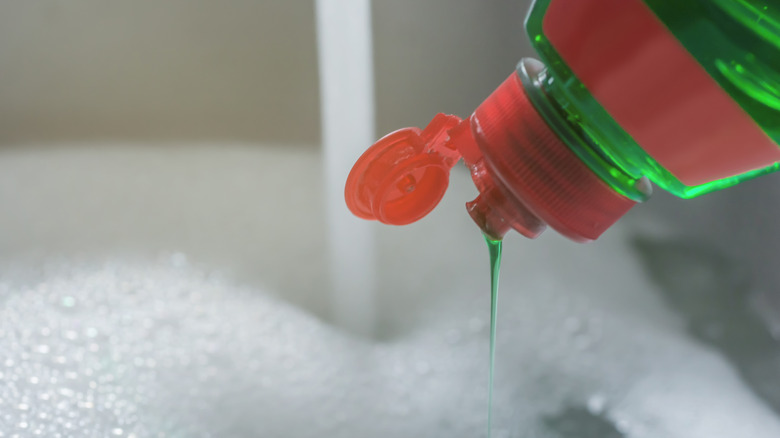 Dish soap being poured into a sink